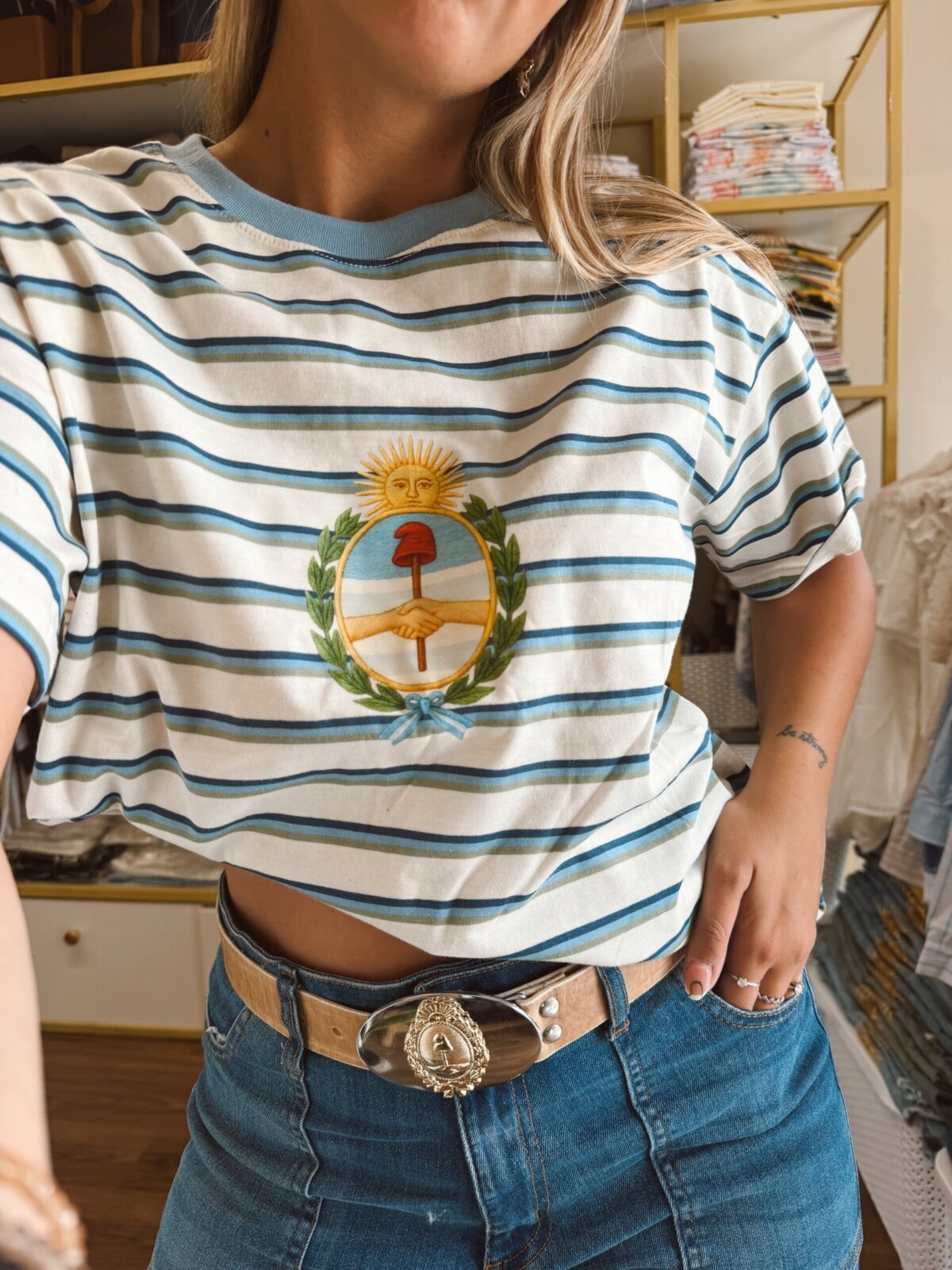 REMERA RAYADA CELESTE ESCUDO